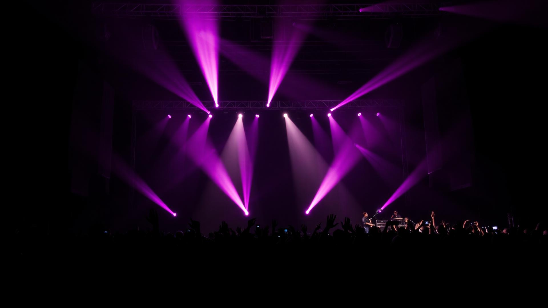 Outdoor concert at dusk with a large stage, LED wall and moving lights